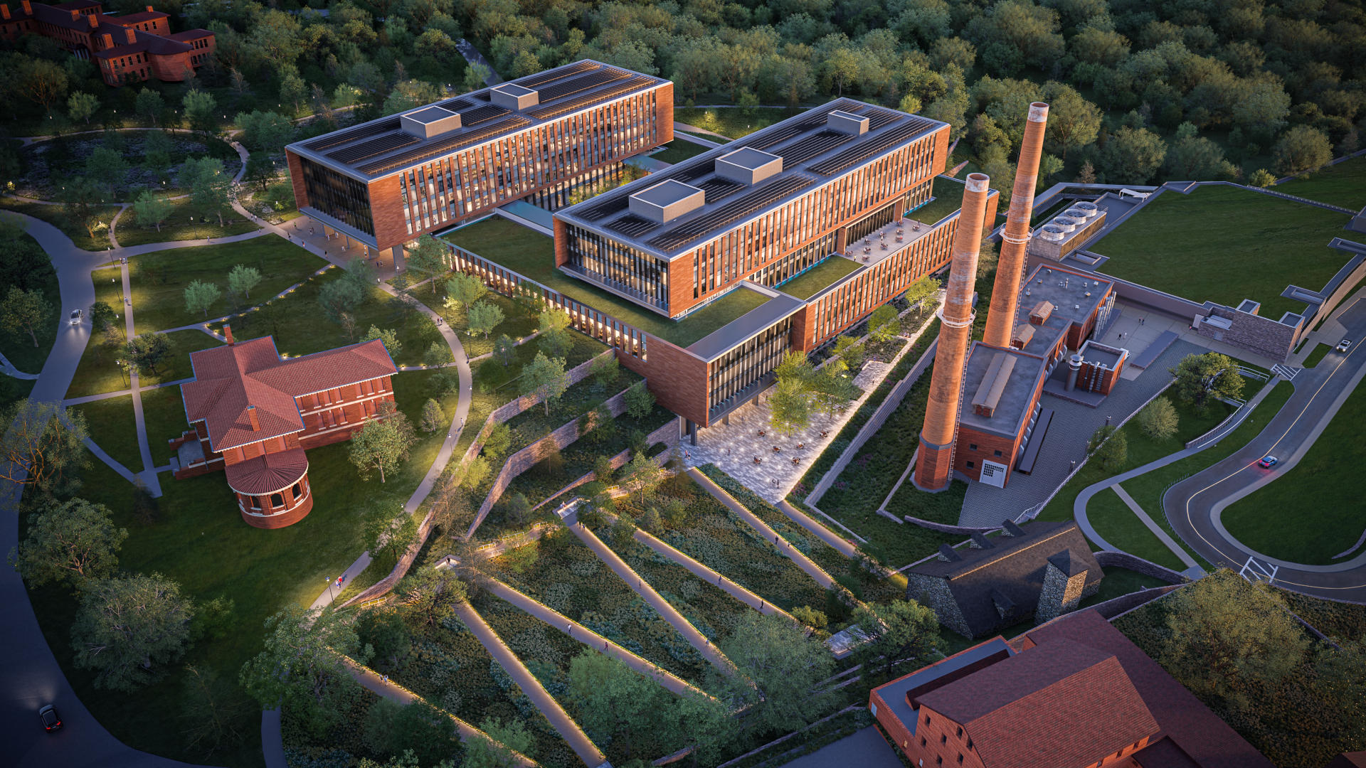 A aerial rendering of the new CISA HQ building and central utility plant. The buildings are red brick and surrounded by green landscaping. There is a large, terraced office building in the center with two main towers. The utility plant with two tall smokestacks is shown to the right. There are three other smaller brick buildings surround them. There's also prominent terracing in the landscaping, creating a zigzag walking path in the foreground.